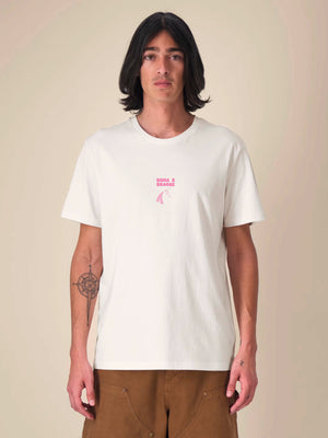 T-shirt BUMA X BRAGHE colore Naturale vista da davanti, con piccola stampa rosa BUMA X BRAGHE al centro del petto
