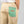 Dettaglio della tasca posteriore verde con zip e logo Braghe rosso dei pantaloni LO SPECCHIO Limited Edition